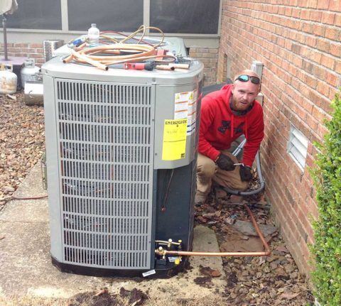One of our skilled techs repairing a customer's air conditioning unit