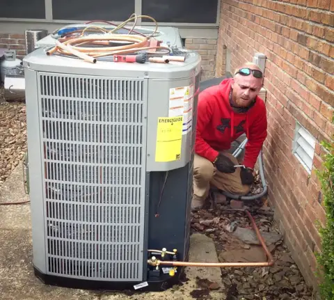 One of our skilled techs repairing a customer's air conditioning unit